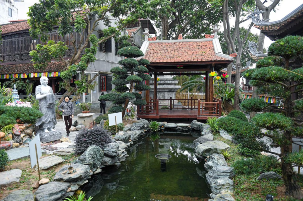 The pond often features blooming lotus flowers, which are significant in Buddhism