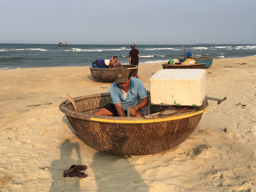Local fisherman at Hoi An beach sunrise traditional basket boat