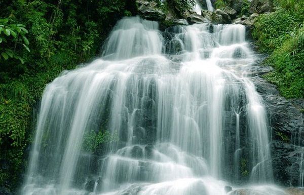 The waterfall cascades down from above, bursting into a torrent of white foam